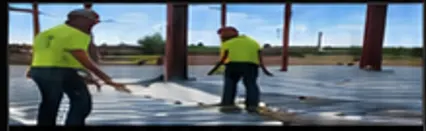Workers installing metal decking on a steel structure