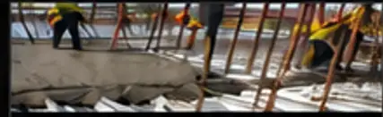 Crew pouring concrete over metal decking on a job site